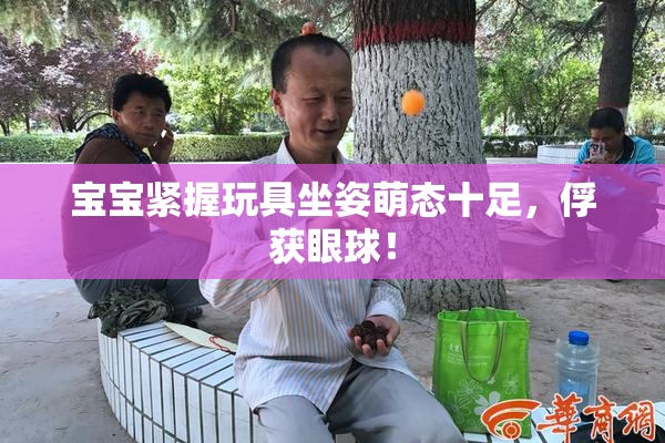 宝宝紧握玩具坐姿萌态十足，俘获眼球！